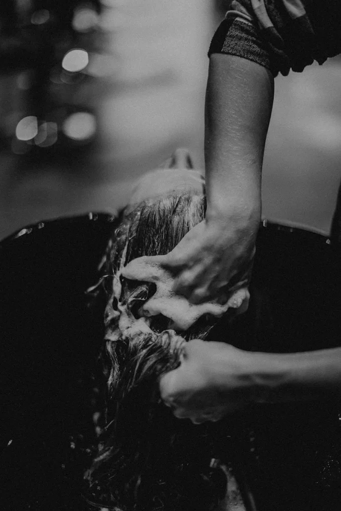 A person is having their hair shampooed in a salon setting
