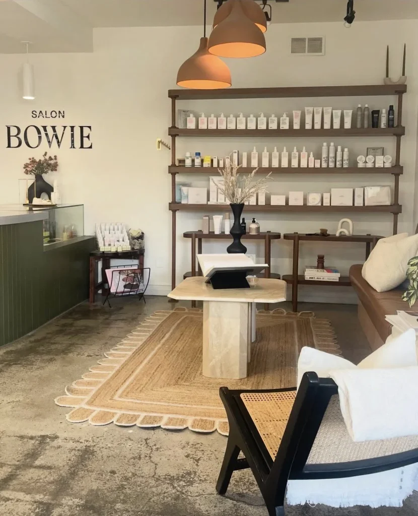 A stylish salon features a welcoming seating area and neatly arranged products on shelves