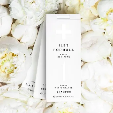 A white shampoo box is surrounded by delicate white flowers