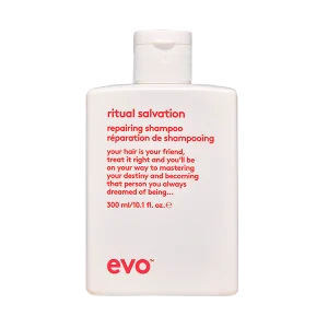 A white shampoo bottle prominently displays branding and instructions on a simple background