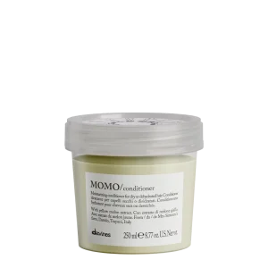 A small, labeled container of conditioning cream sits on a flat surface