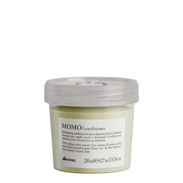 A small, labeled container of conditioning cream sits on a flat surface
