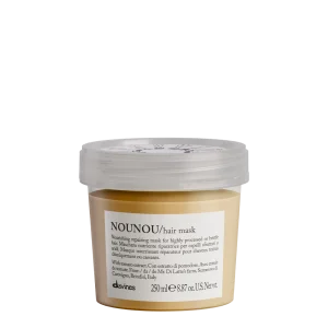 A clear jar contains a creamy hair mask with a light yellow hue