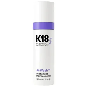 A sleek, white bottle with purple accents contains dry shampoo, highlighting a modern design