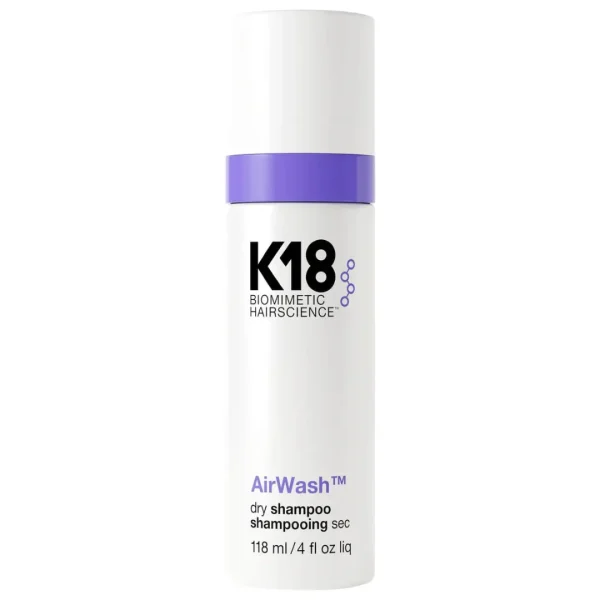 A sleek, white bottle with purple accents contains dry shampoo, highlighting a modern design