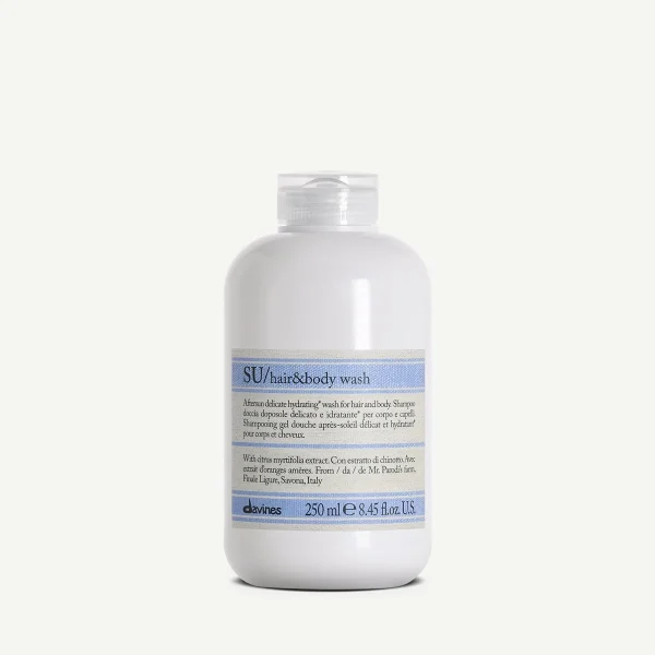 A white bottle labeled "SU/hair&body wash" sits against a plain background