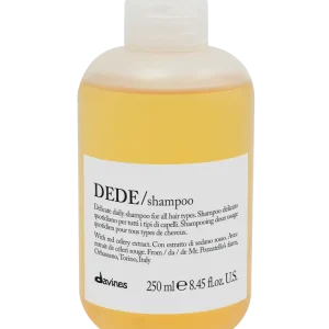 A clear bottle contains orange shampoo with a simple, minimalist design