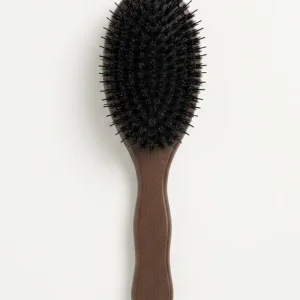A textured hairbrush with a brown handle rests against a light background