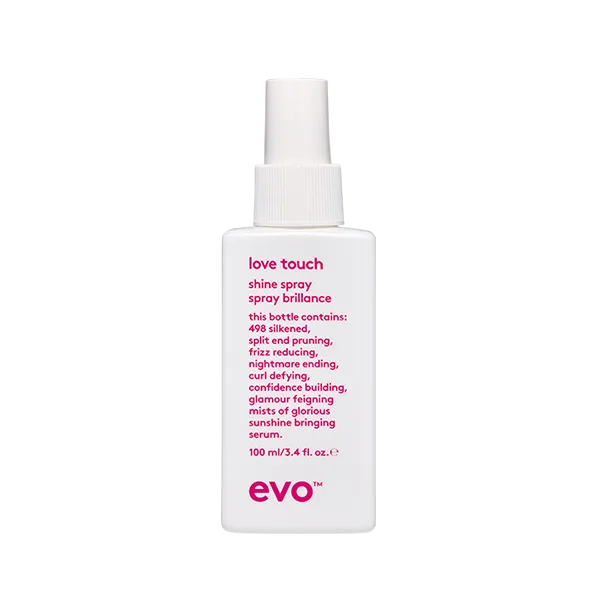 A clear spray bottle with a white label and pink text sits upright