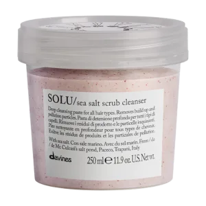 A clear container holds a pink, textured sea salt scrub with an attached label