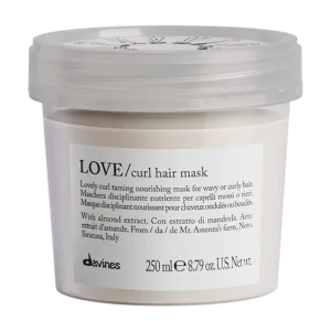 A sealed container holds a creamy hair mask labeled for nourishing curly hair