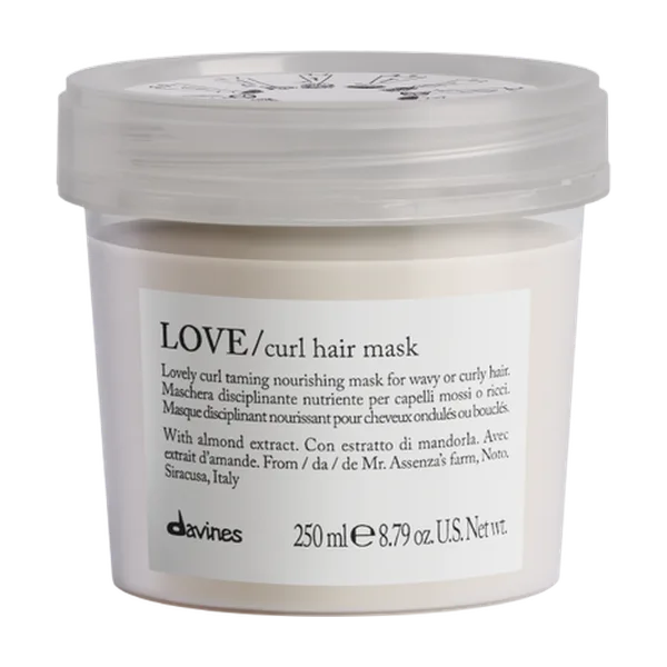 A sealed container holds a creamy hair mask labeled for nourishing curly hair