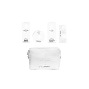 A neatly arranged skincare set includes bottles, a comb, and a branded pouch