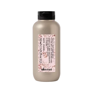 A sleek, beige bottle of shampoo with a decorative label sits upright
