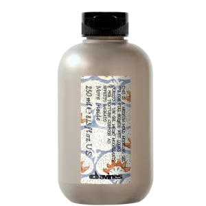 A bottle contains a creamy substance with decorative labeling and a black cap