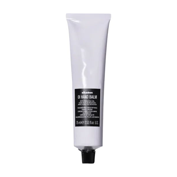 A white tube of hand balm with a black label lies against a plain background