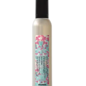 A sleek bottle holds a floral-patterned label, showcasing a hair product