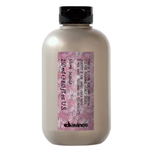 A bottle with a floral label contains a hair care product