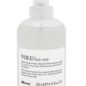 A clear spray bottle filled with hair mist sits on a flat surface