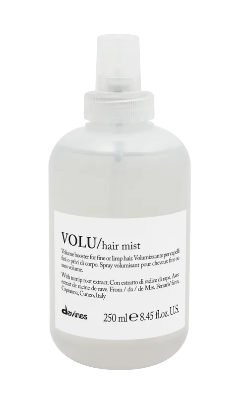 A clear spray bottle filled with hair mist sits on a flat surface