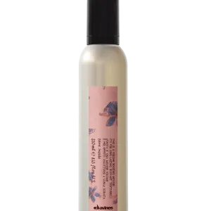 A slim bottle with a pink label and black cap contains a creamy liquid
