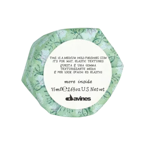 A hexagonal container displays floral patterns and text about a hair styling product