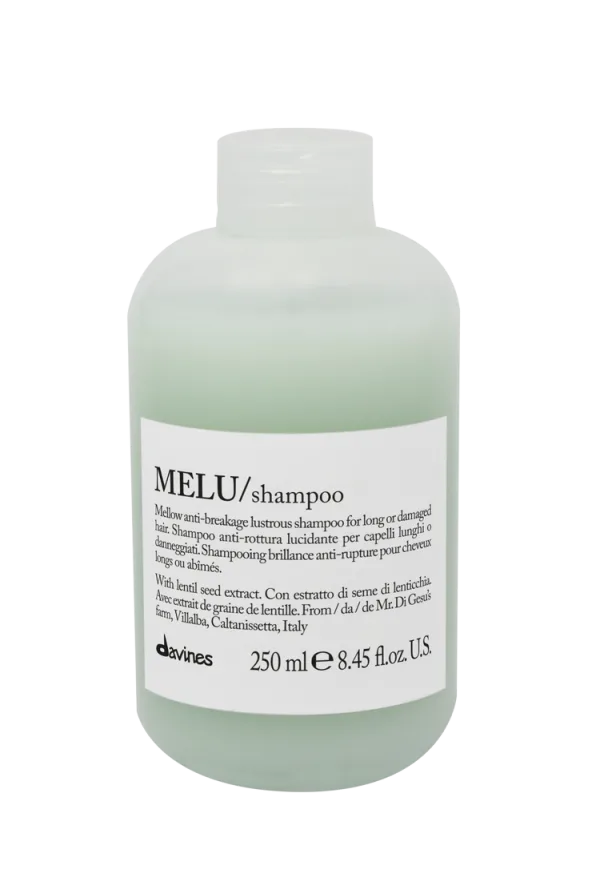 A clear bottle of shampoo with a minimalist label and light green liquid