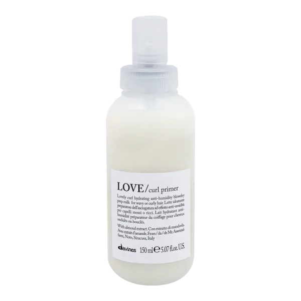 A clear spray bottle contains a creamy hair product labeled as curl primer