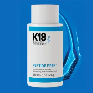 A sleek white shampoo bottle is centered against a vibrant blue background