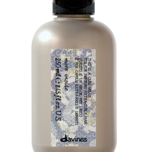 A beige bottle with a black cap and floral label is displayed against a neutral background