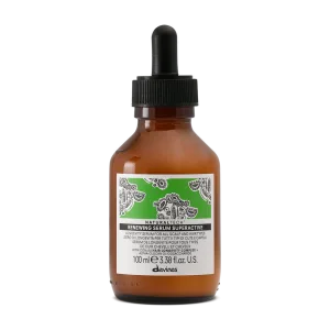 A small amber glass bottle with a dropper cap contains a green serum