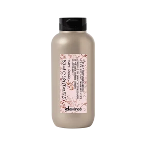 A sleek, light-colored bottle with a decorative label stands upright against a plain background