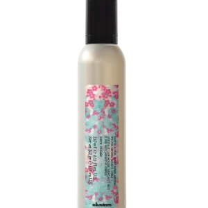 A sleek bottle of hair product features floral decoration and clear labeling