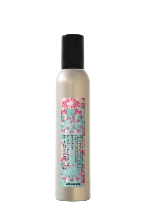 A sleek bottle of hair product features floral decoration and clear labeling