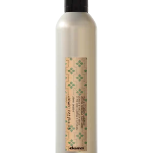A sleek, silver bottle contains a cream-colored liquid, decorated with a patterned label
